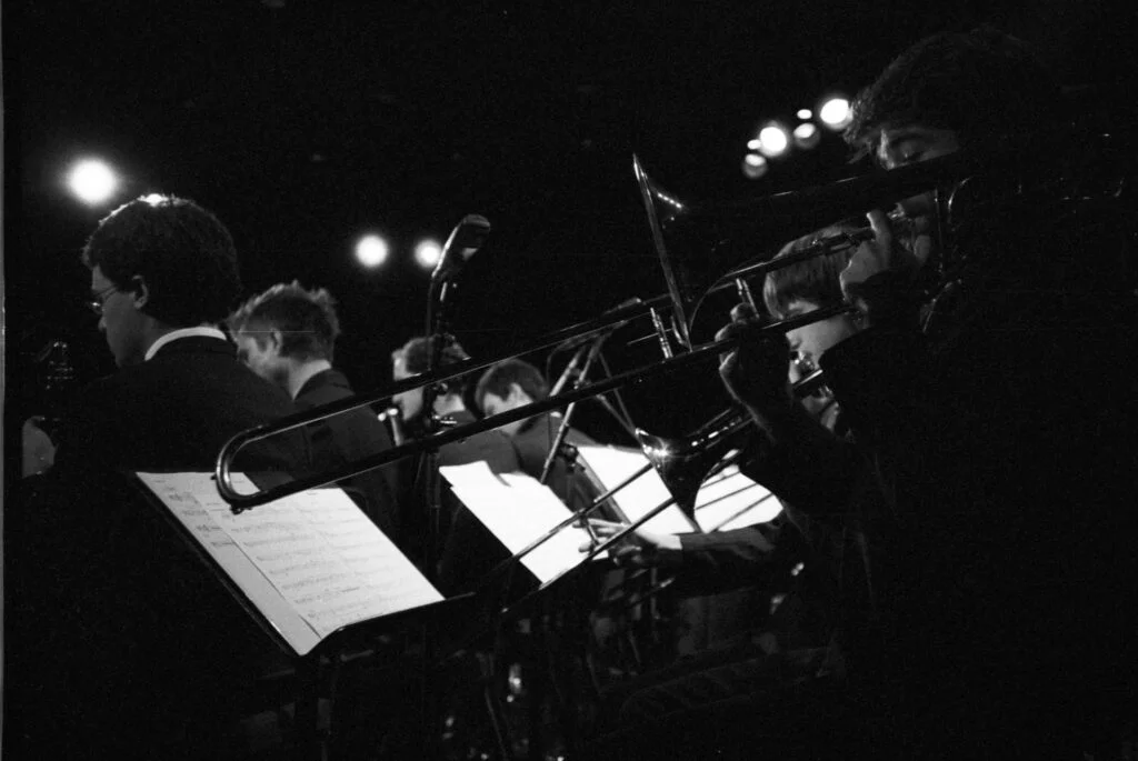 Trombone players in an orchestra, photographed in black and white